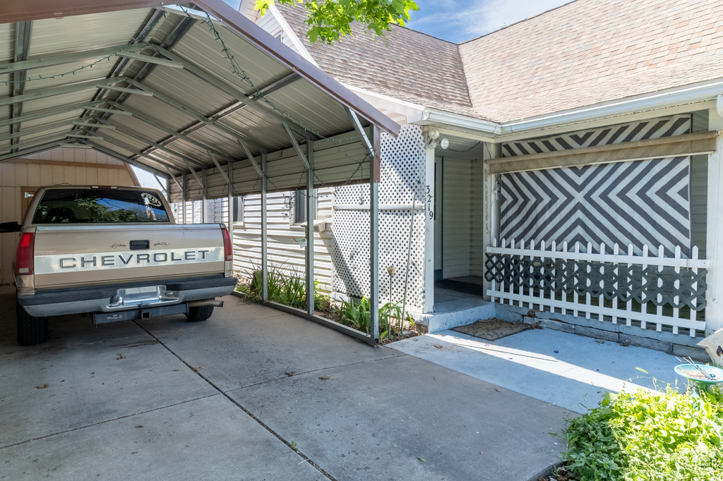 View of vehicle parking featuring driveway and a detached carport