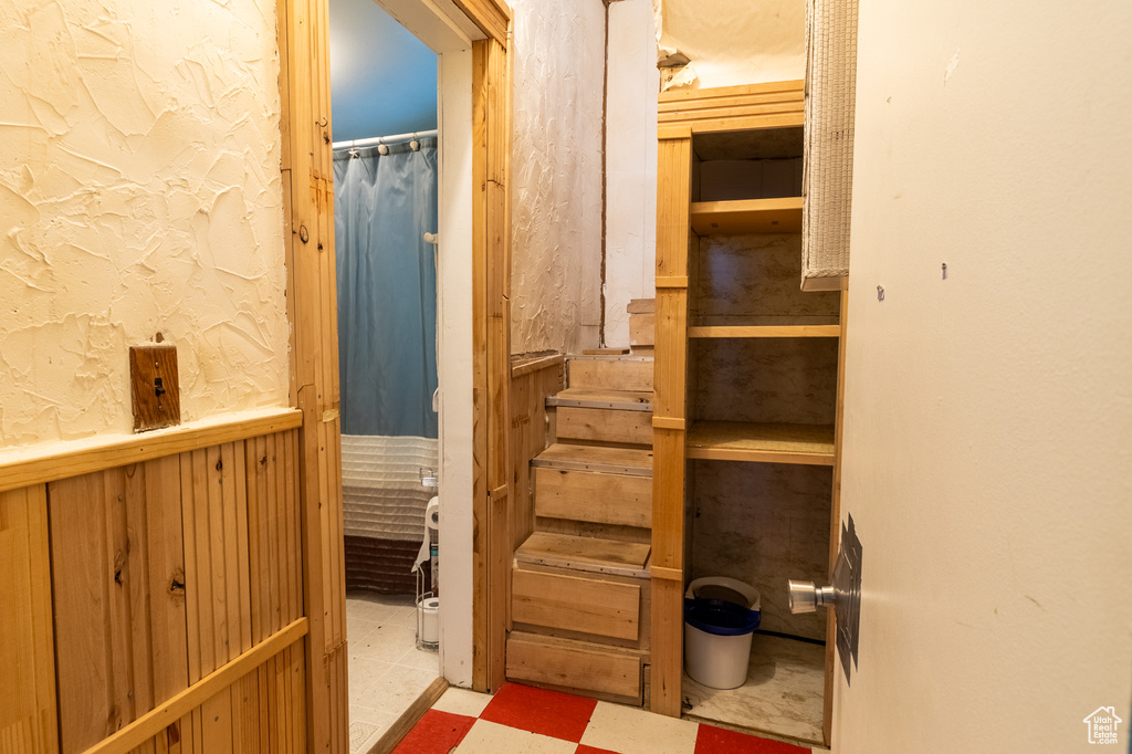 Bathroom with tile patterned floors and a wainscoted wall
