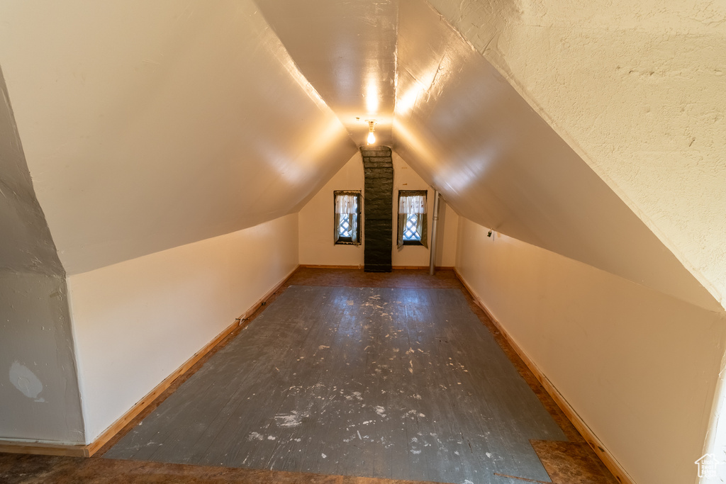 Additional living space featuring vaulted ceiling, baseboards, and wood finished floors