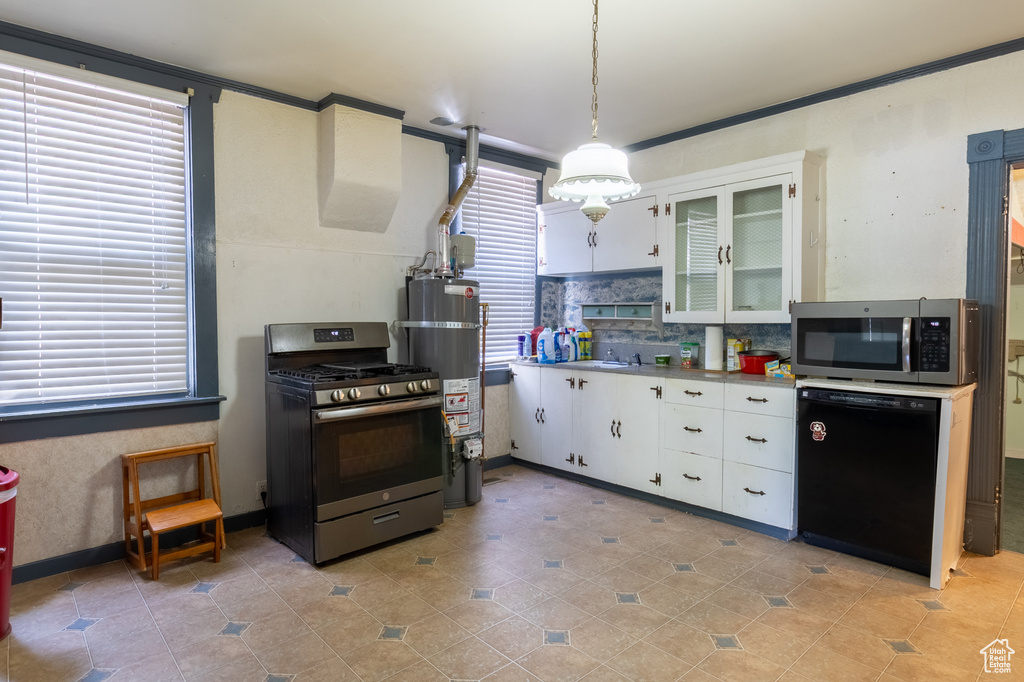 Kitchen with appliances with stainless steel finishes, strapped water heater, white cabinetry, decorative backsplash, and decorative light fixtures