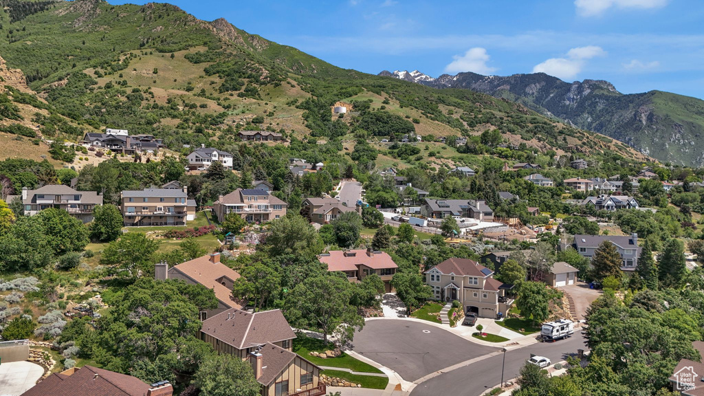 Aerial overview of property's location featuring a mountainous background and nearby suburban area
