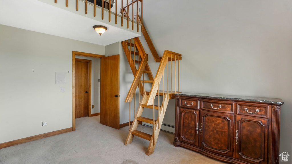 Stairs with carpet floors, baseboards, and a baseboard radiator