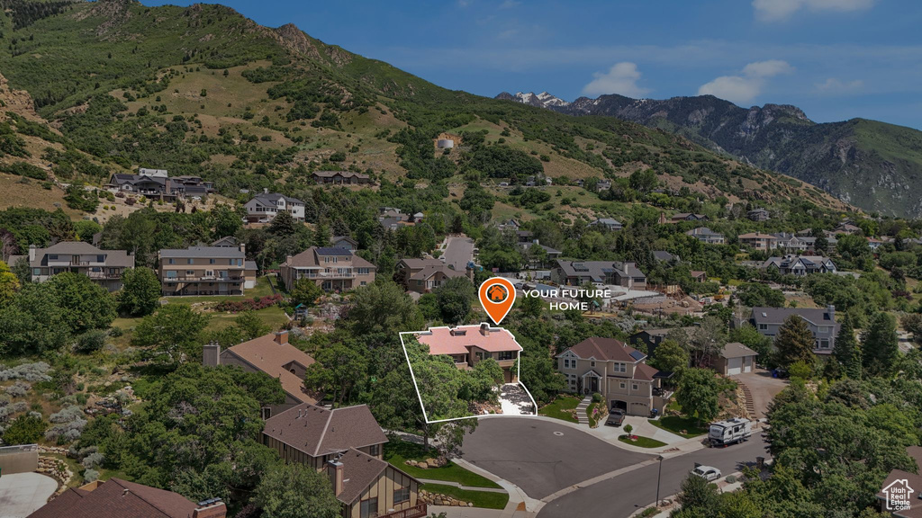 Aerial view of property's location featuring a mountain backdrop, nearby suburban area, and property parcel outlined