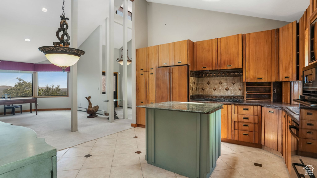 Kitchen featuring paneled built in refrigerator, a kitchen island, high vaulted ceiling, brown cabinetry, and light colored carpet