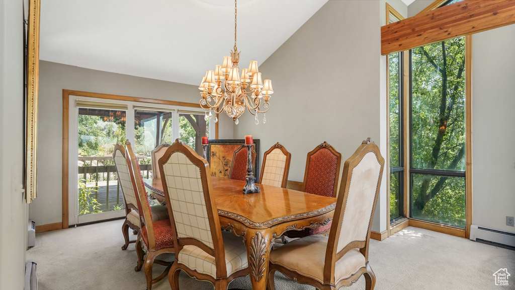 Dining space featuring light colored carpet, a chandelier, a baseboard radiator, vaulted ceiling, and baseboards