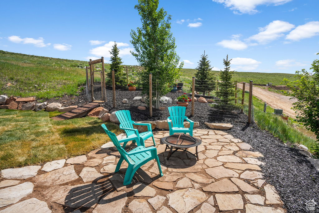 View of patio / terrace with a fire pit, a rural view, and agricultural plots