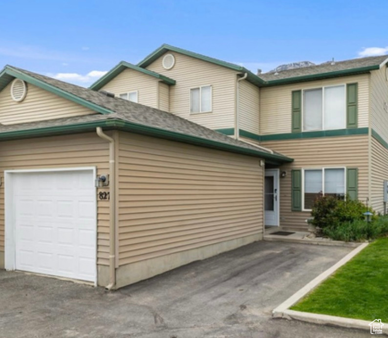 View of front of property featuring an attached garage and driveway