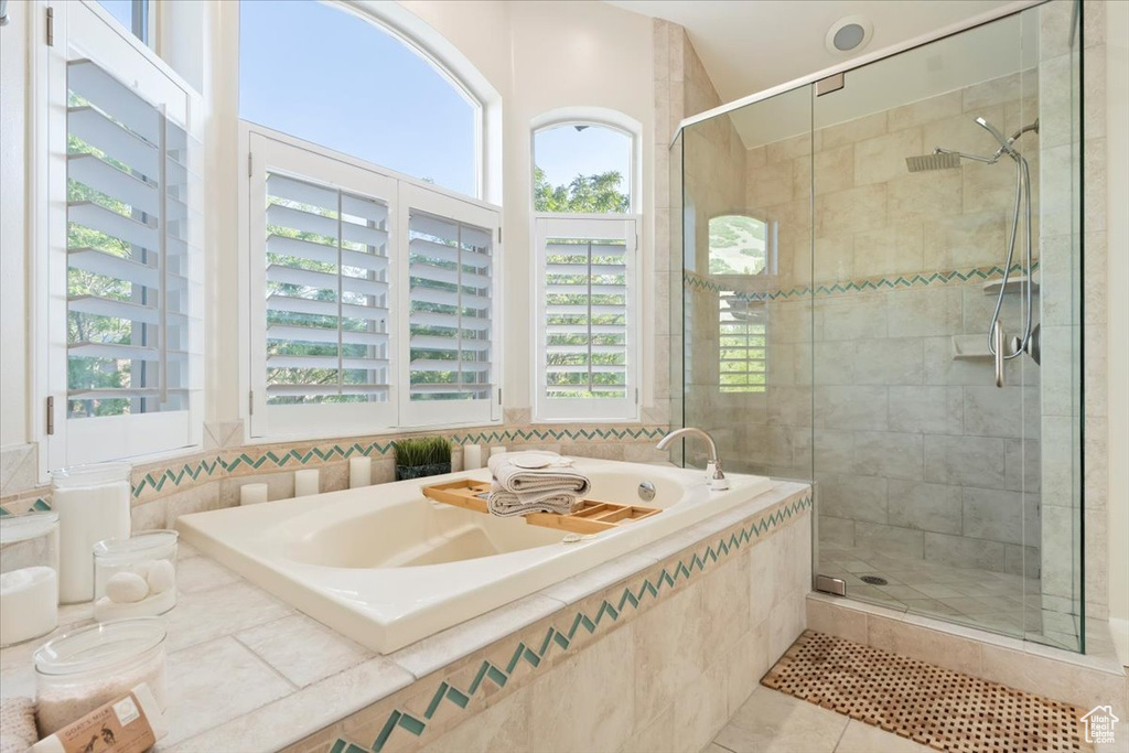 Bathroom with plenty of natural light, a stall shower, and a bath