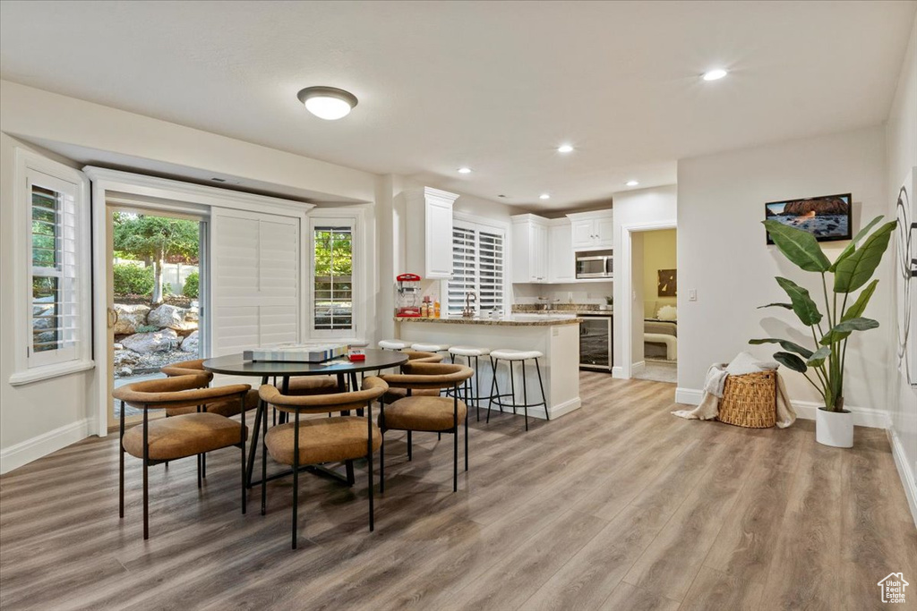 Dining area with light wood-style floors, baseboards, and recessed lighting