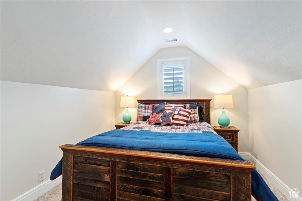 Bedroom with carpet flooring, vaulted ceiling, and baseboards