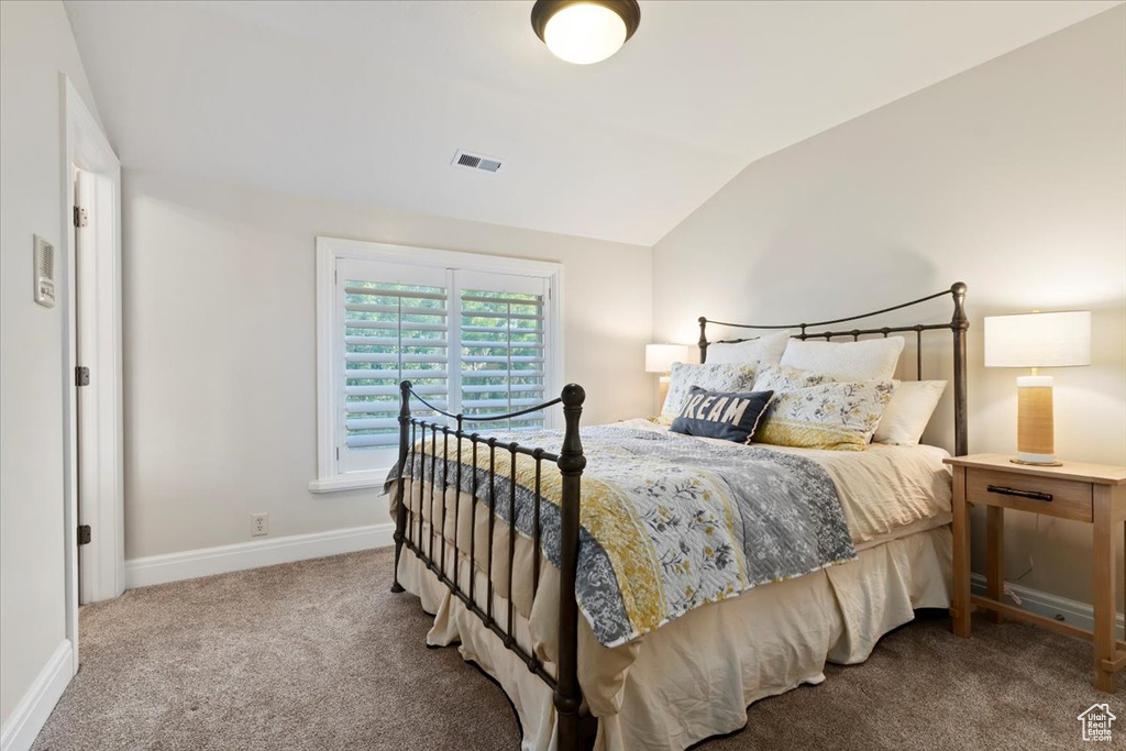 Bedroom with carpet floors, vaulted ceiling, and baseboards
