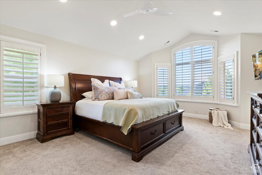 Bedroom with multiple windows, light colored carpet, lofted ceiling, baseboards, and recessed lighting
