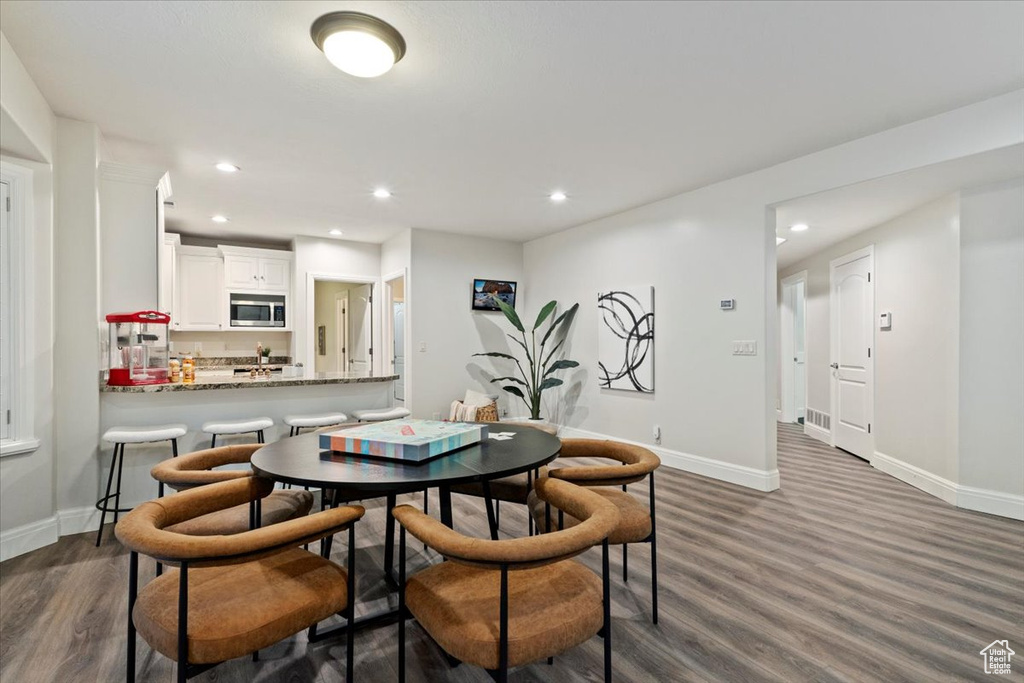 Dining space featuring dark wood-type flooring, baseboards, and recessed lighting