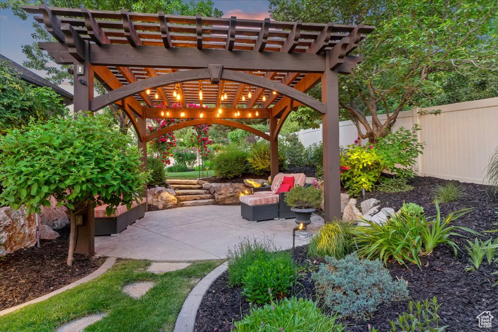 Patio terrace at dusk featuring a pergola and a patio area
