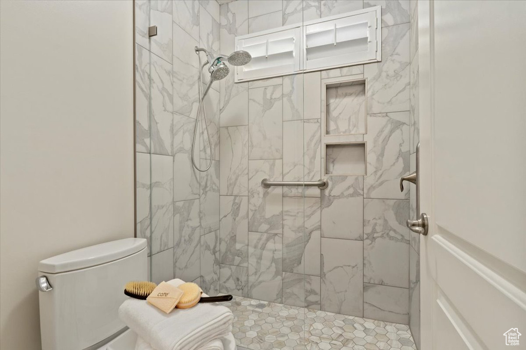 Full bath with toilet and a tile shower