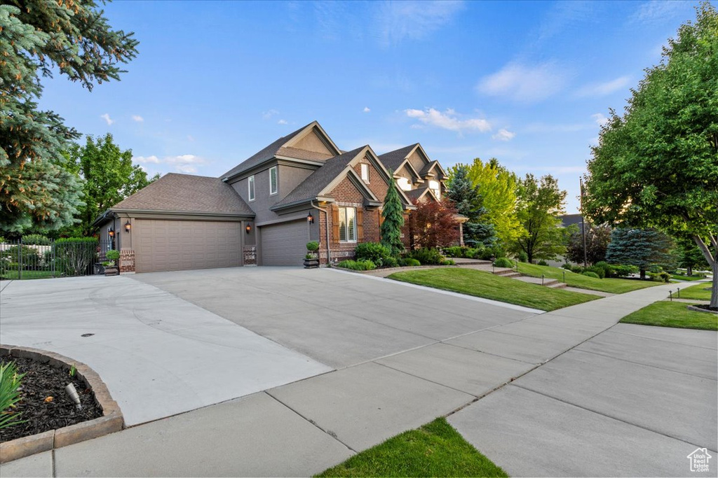 View of front of property with a garage, driveway, and brick siding