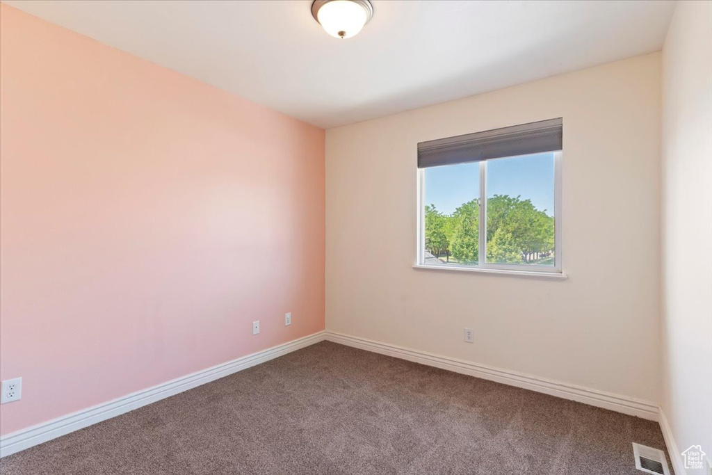 Spare room featuring carpet and baseboards