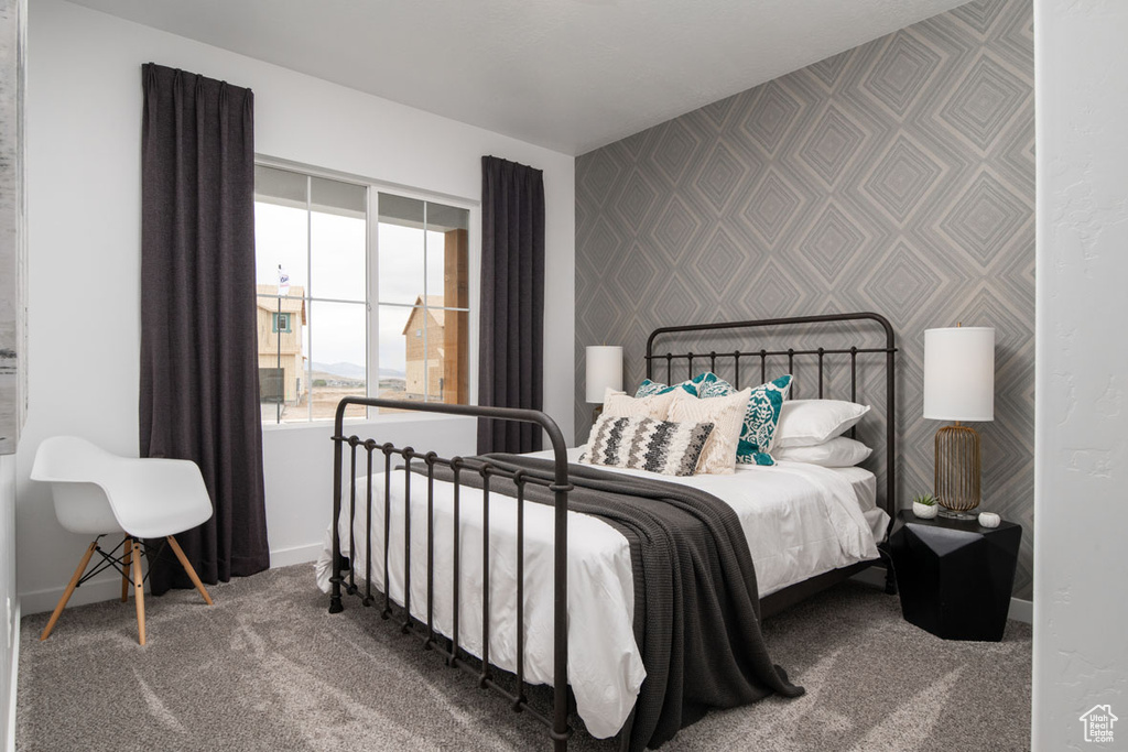 Bedroom featuring wallpapered walls, baseboards, and carpet