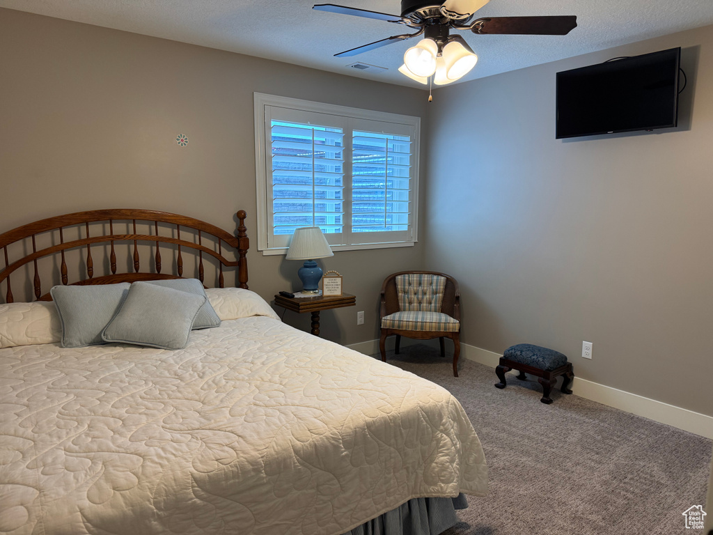 Bedroom with carpet, baseboards, and a ceiling fan