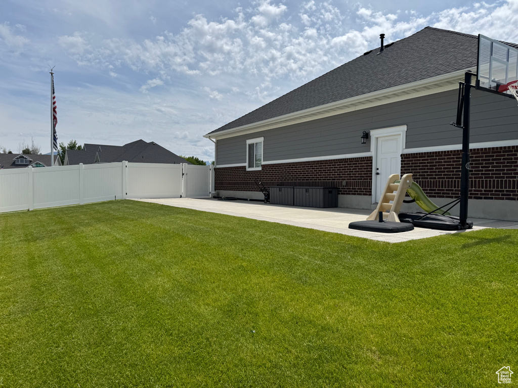 Back of property featuring brick siding, a patio, and a shingled roof
