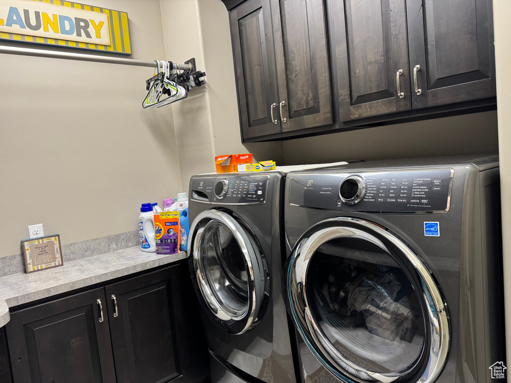 Washroom featuring cabinet space and washing machine and dryer