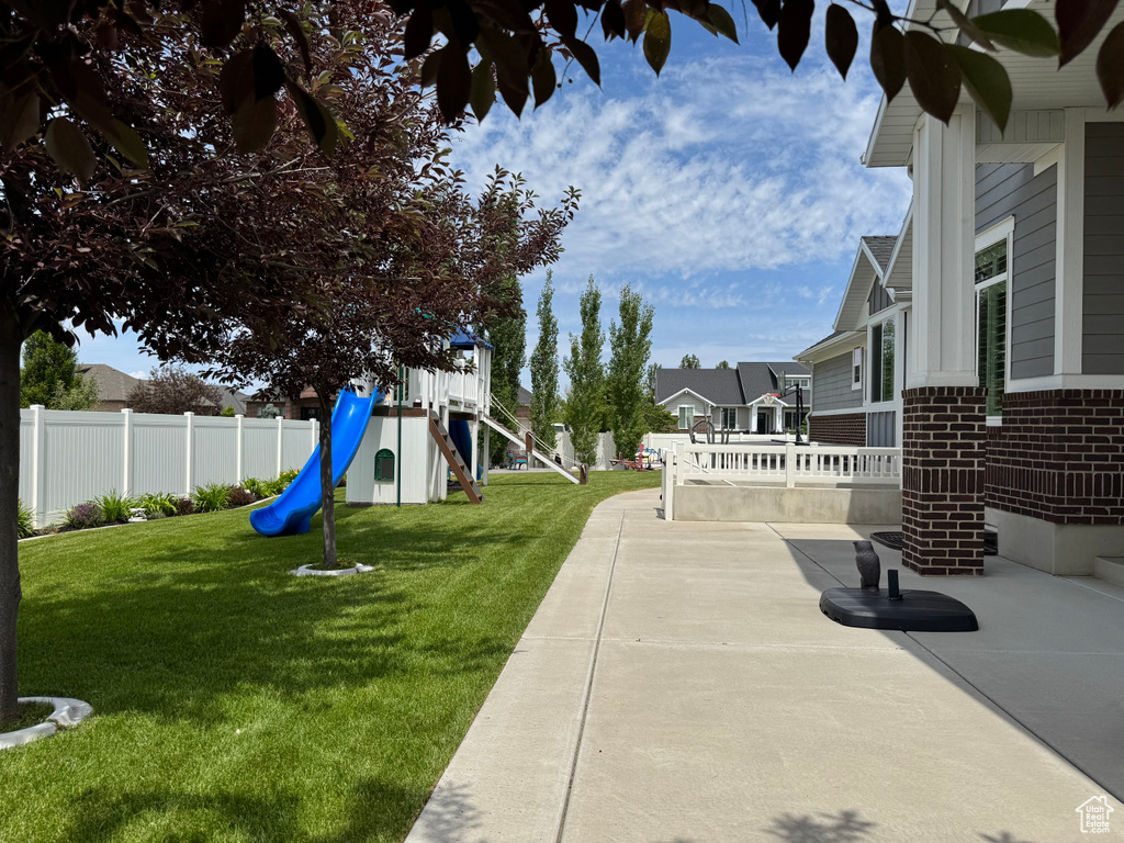 View of yard with a playground, a patio, and a residential view