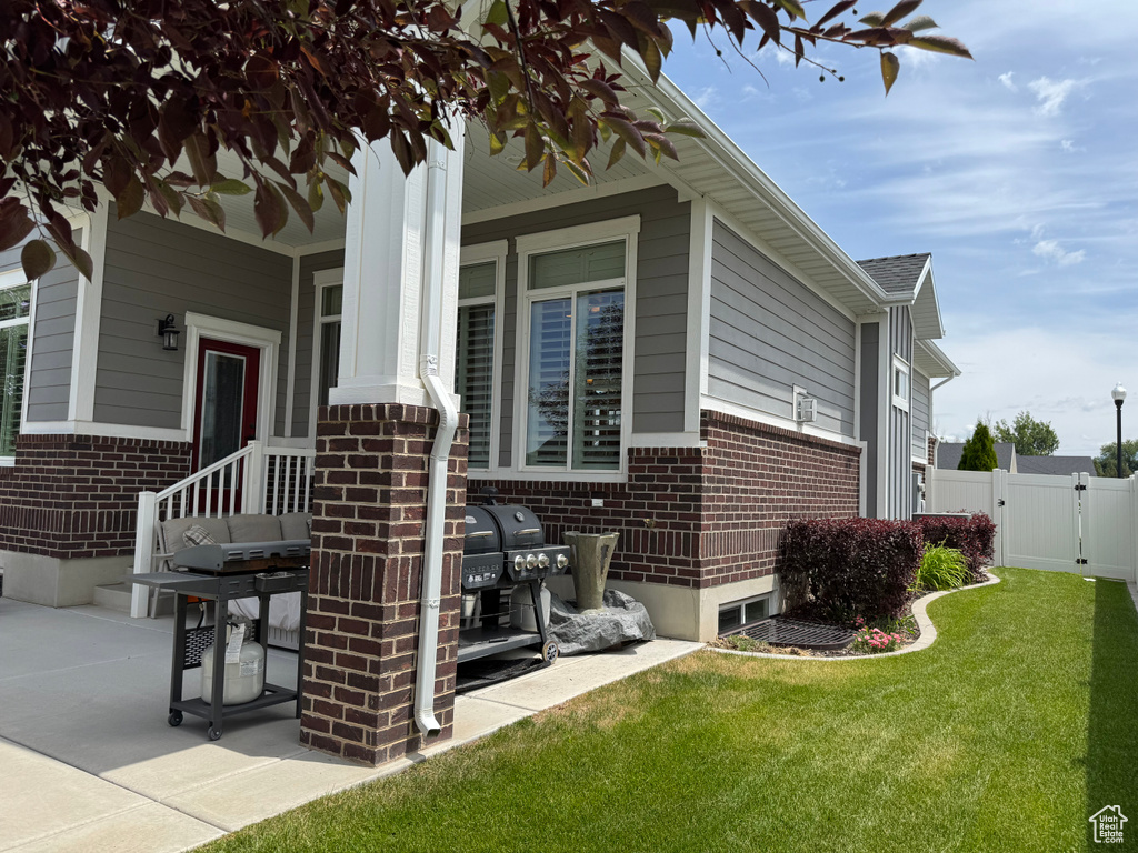 View of side of home featuring brick siding and a gate