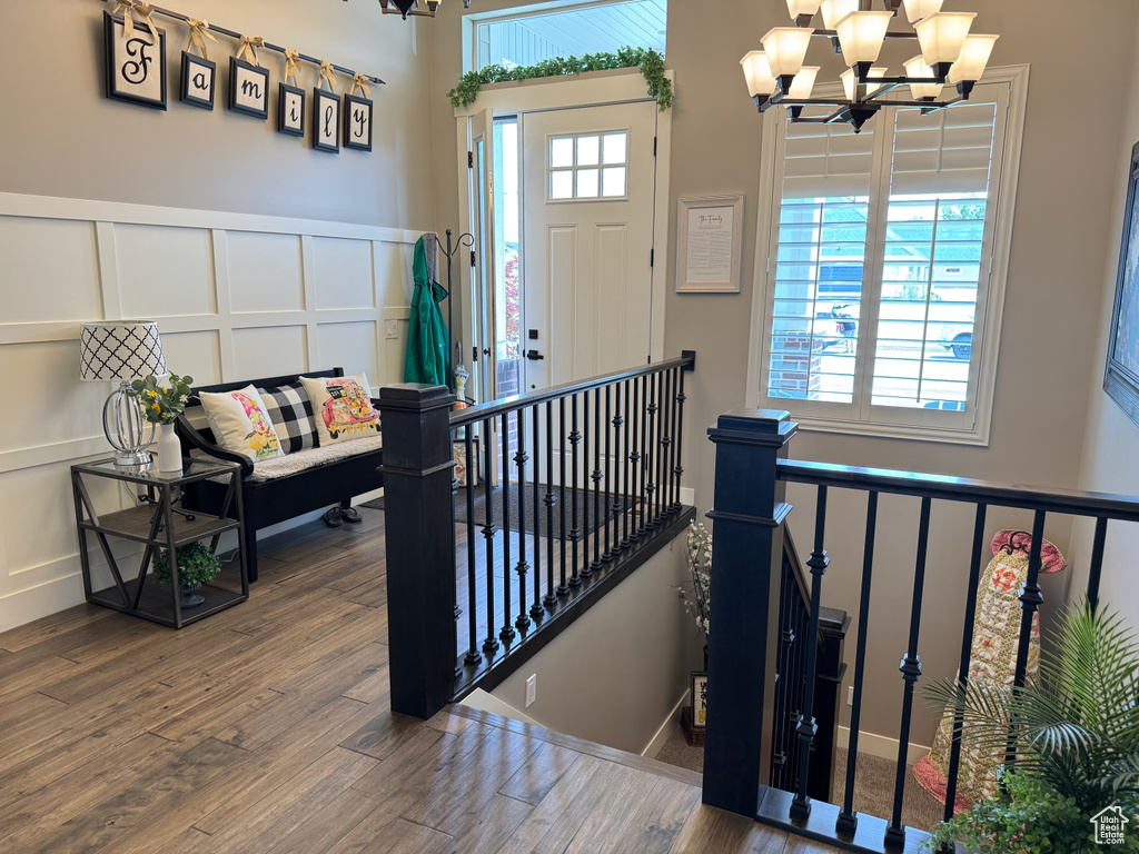 Foyer entrance featuring a decorative wall, a chandelier, and wood finished floors