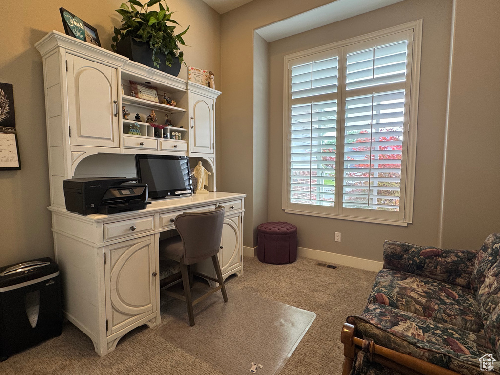Office space with light carpet and baseboards