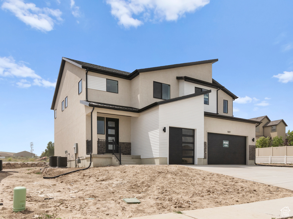 Contemporary home featuring a garage, driveway, and stucco siding