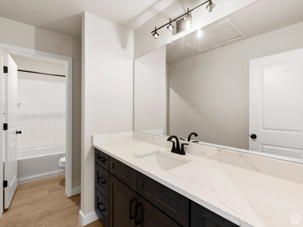 Full bath with vanity, wood finished floors, and tub / shower combination