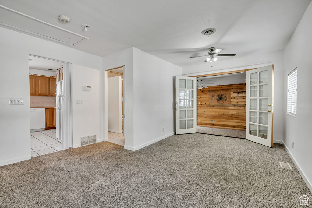 Spare room with attic access, a smoke detector, a ceiling fan, light carpet, and baseboards