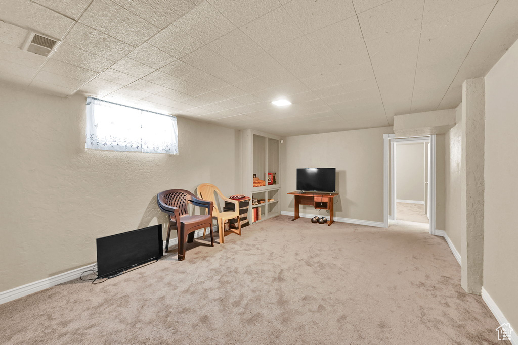 Sitting room with carpet floors, baseboards, and a textured wall