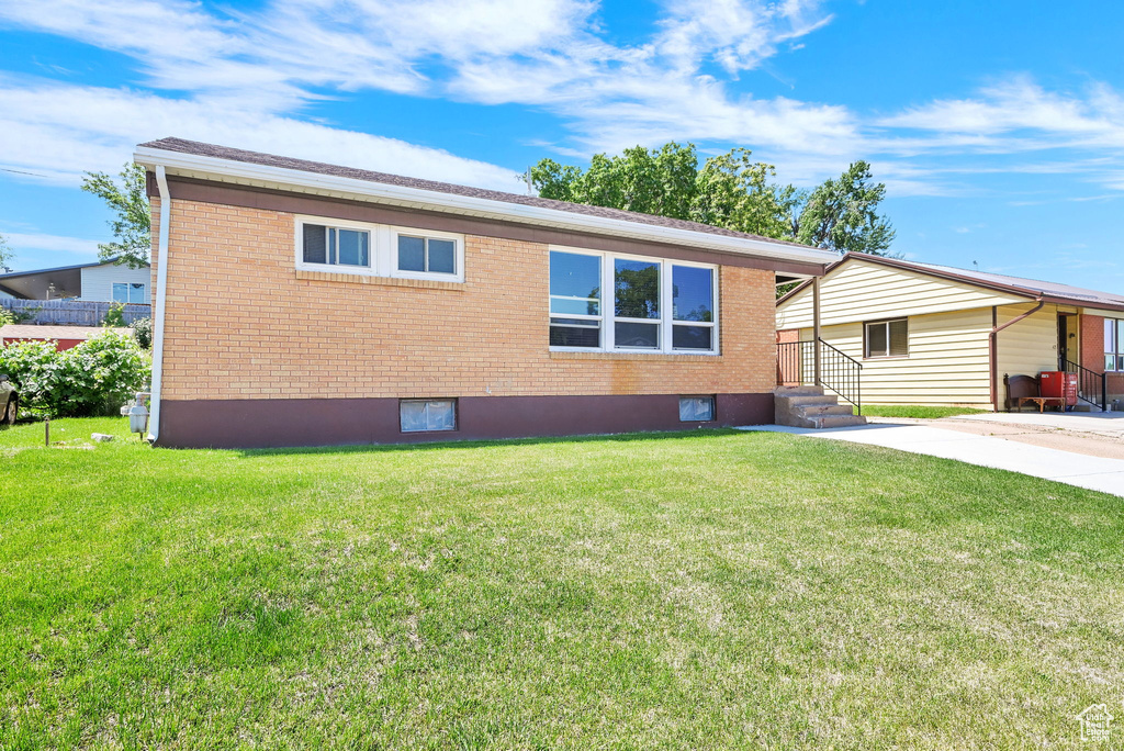 View of front of house with brick siding and a front lawn
