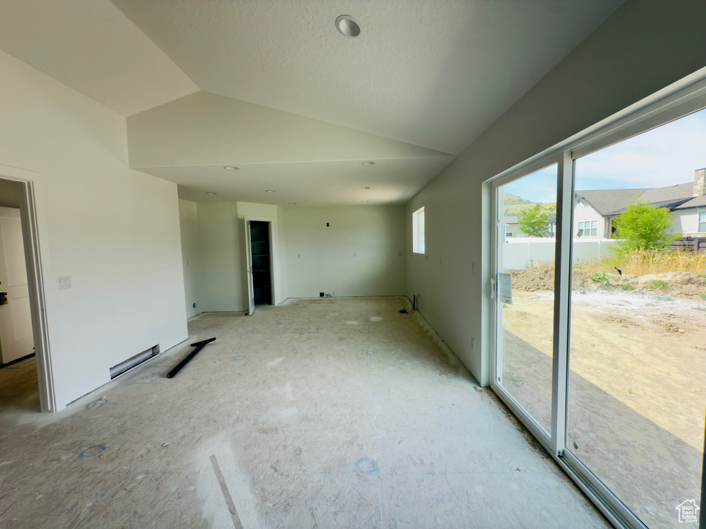 Unfurnished room featuring vaulted ceiling
