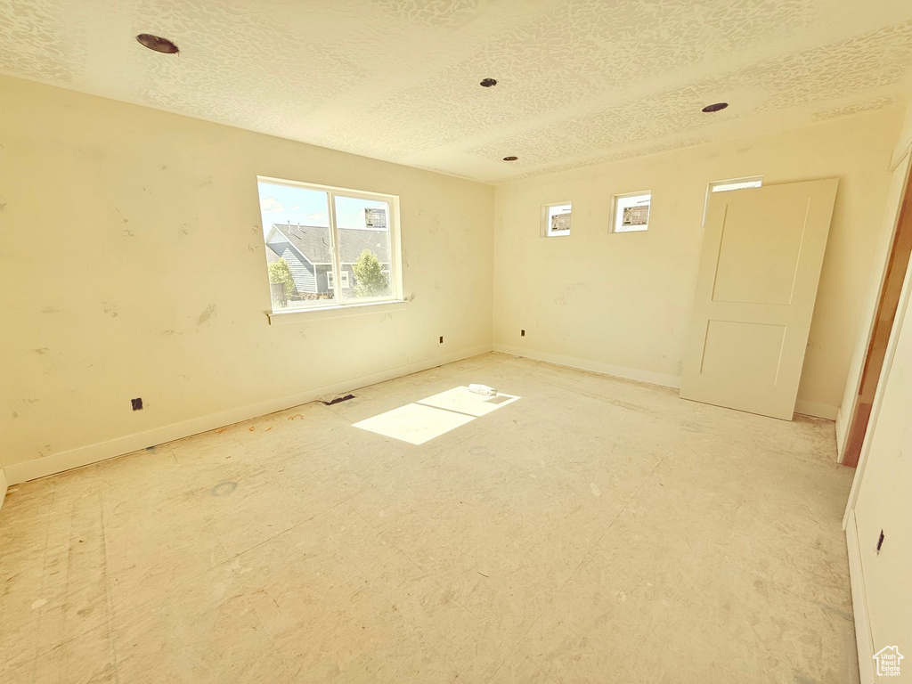 Spare room with a textured ceiling and baseboards