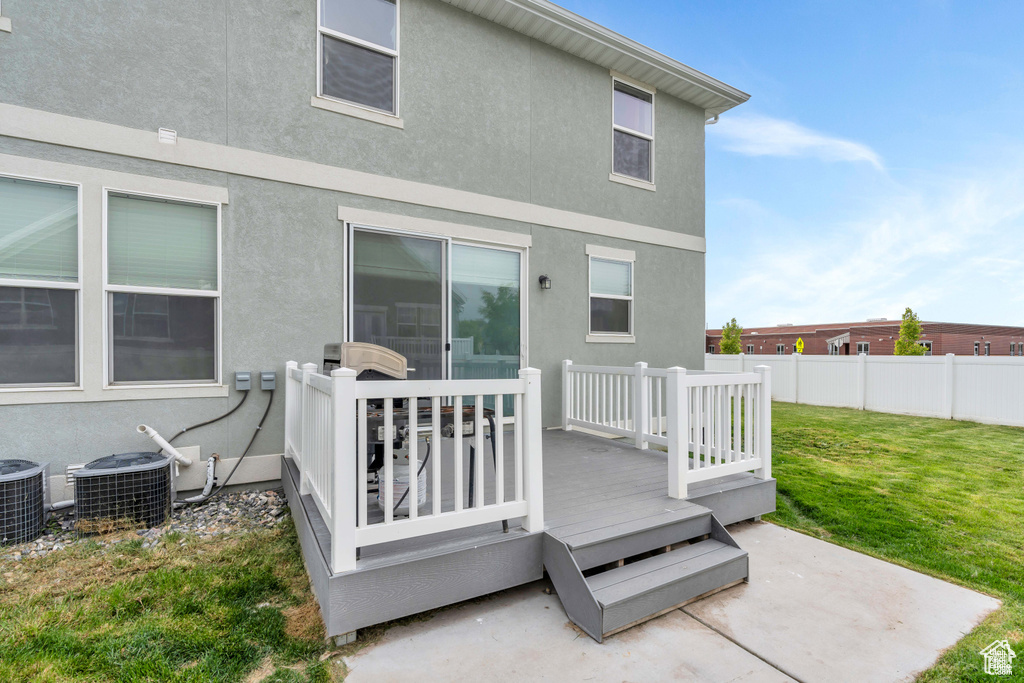 Rear view of property with central AC, a deck, and stucco siding