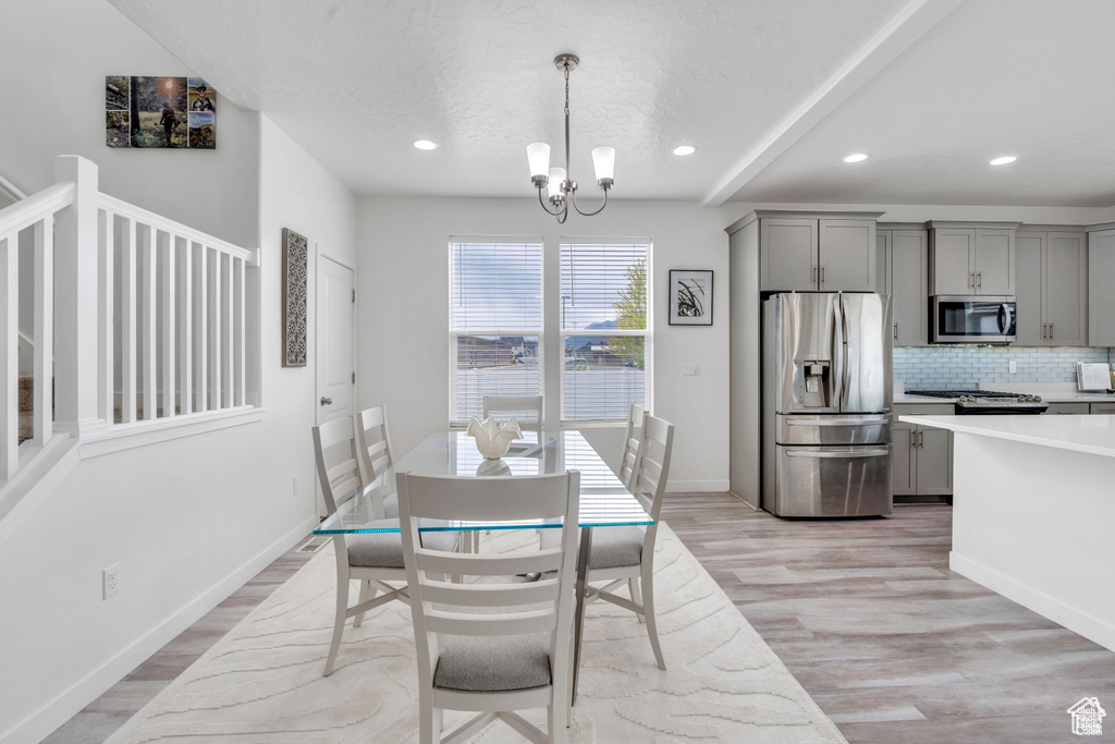 Dining area featuring light wood-style flooring, a chandelier, recessed lighting, and baseboards