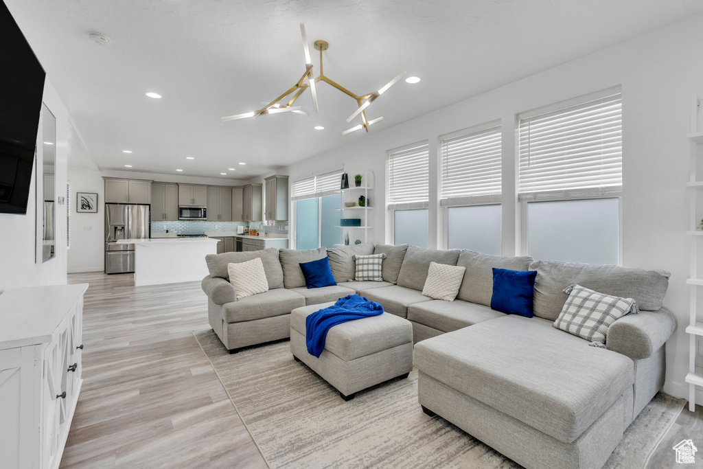 Living room with a chandelier, recessed lighting, and light wood-style flooring