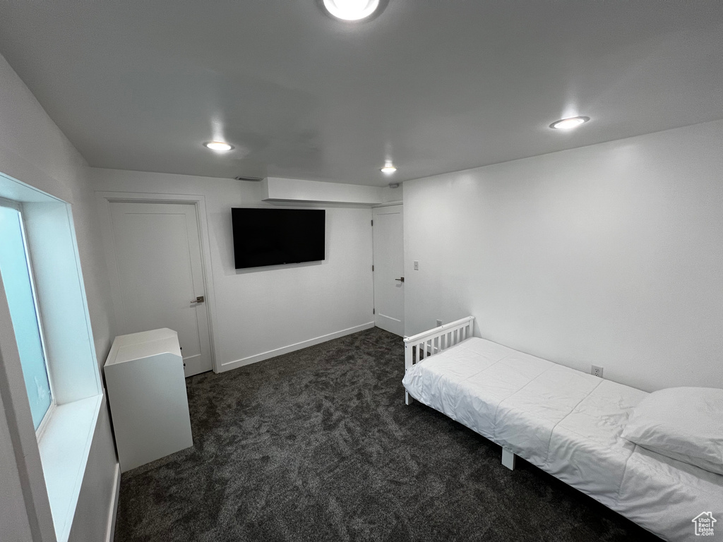 Bedroom with dark carpet, recessed lighting, and baseboards