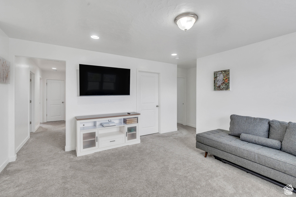 Carpeted living area with baseboards and recessed lighting