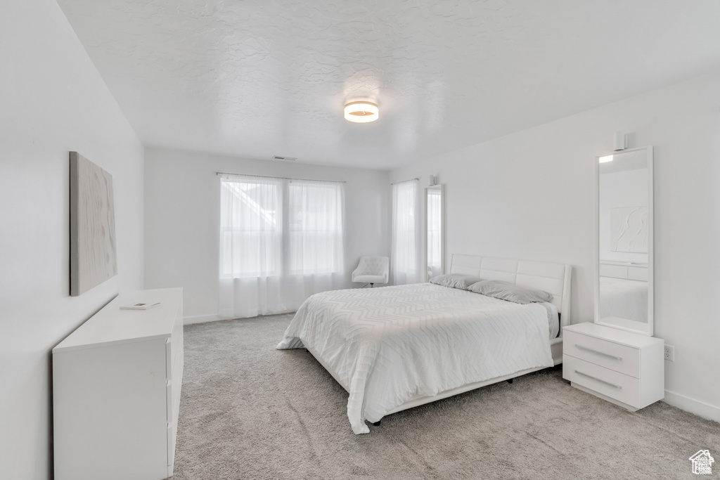 Bedroom featuring light carpet and baseboards