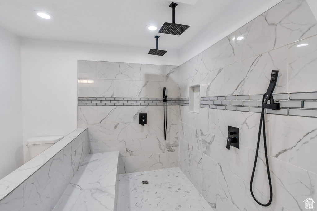 Full bathroom featuring recessed lighting and a marble finish shower