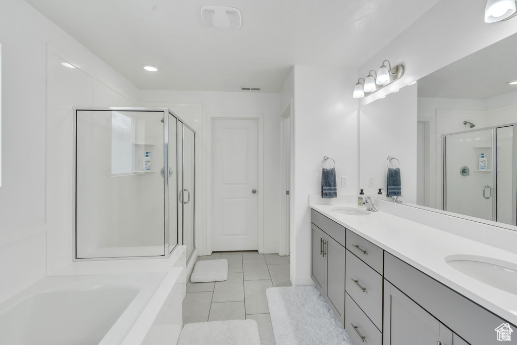 Full bath featuring a shower stall, tile patterned flooring, double vanity, a bath, and recessed lighting