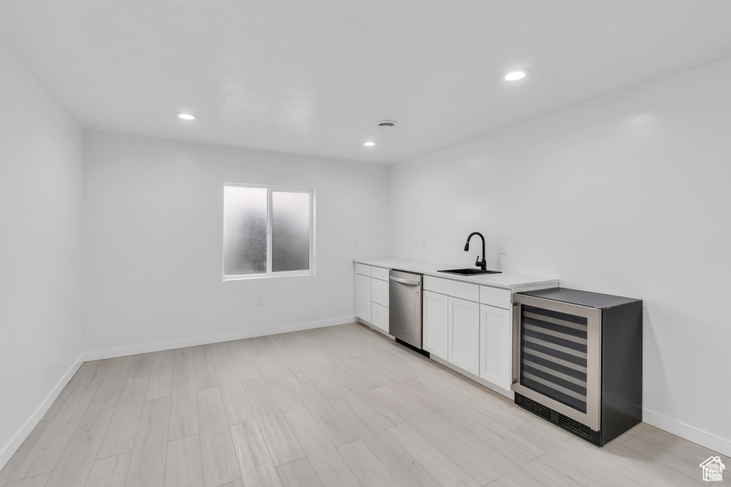Bar area with a sink, dishwasher, wine cooler, light wood finished floors, and recessed lighting