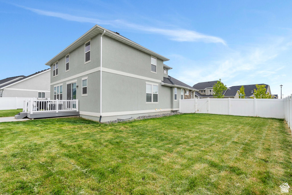 Back of property featuring a wooden deck and stucco siding