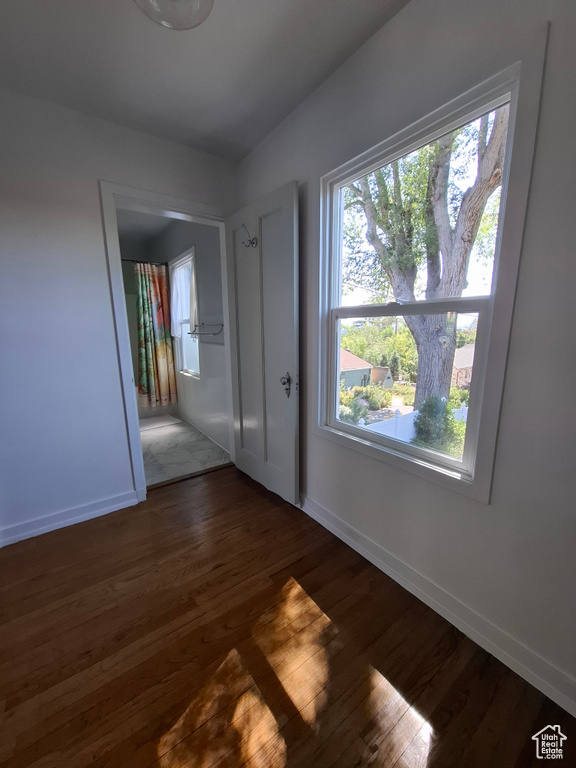 Unfurnished room with wood finished floors and healthy amount of natural light