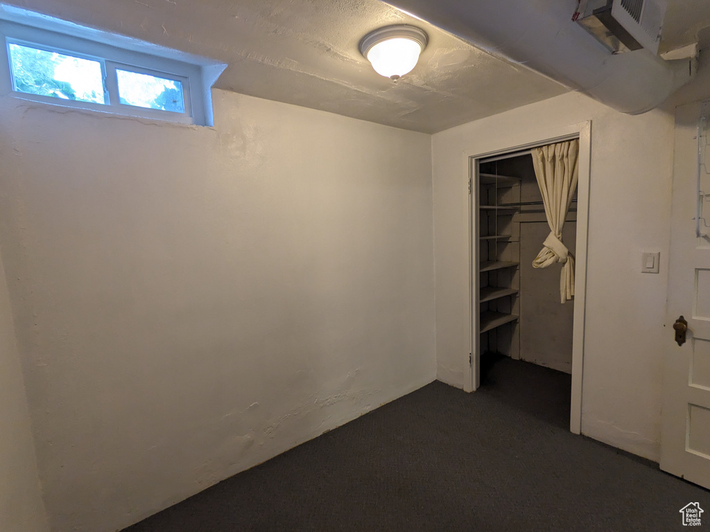 Unfurnished bedroom with a closet and dark carpet