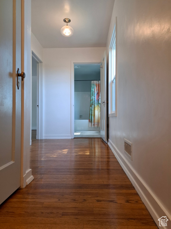 Hallway featuring wood finished floors and baseboards