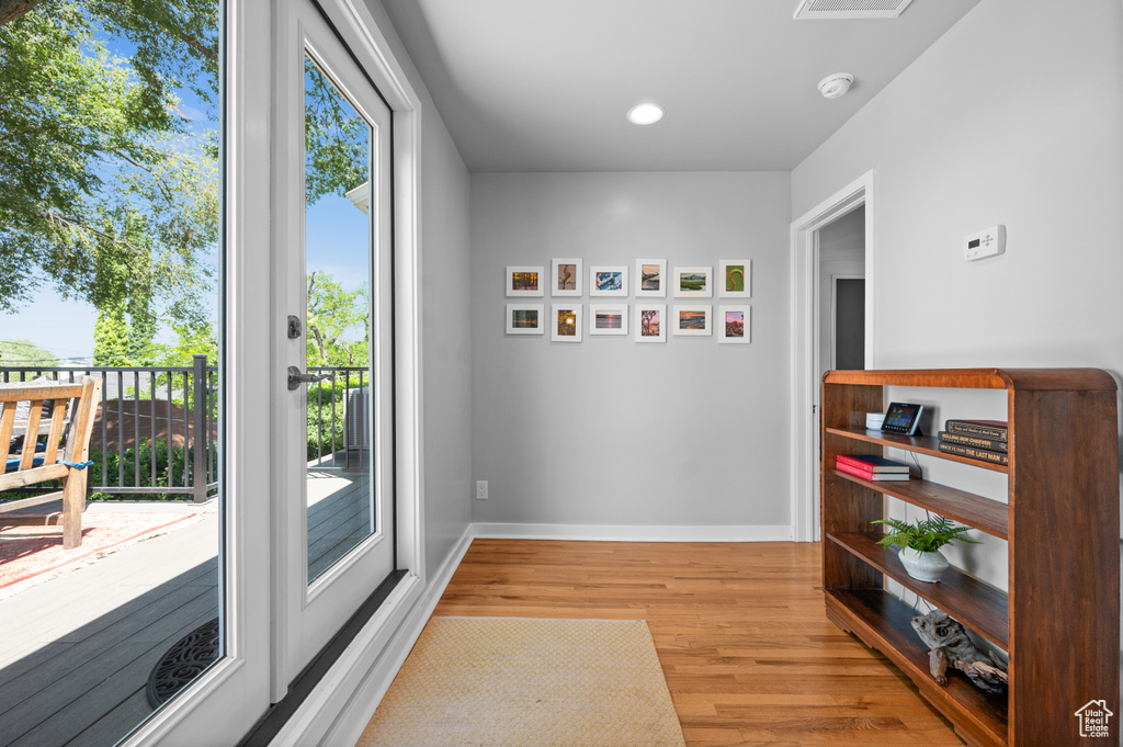 Doorway to outside featuring wood finished floors, baseboards, and plenty of natural light